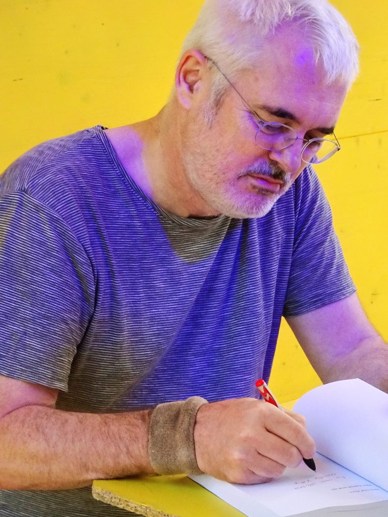 Autor Jens Olaf Koch signiert eines seiner Bücher
